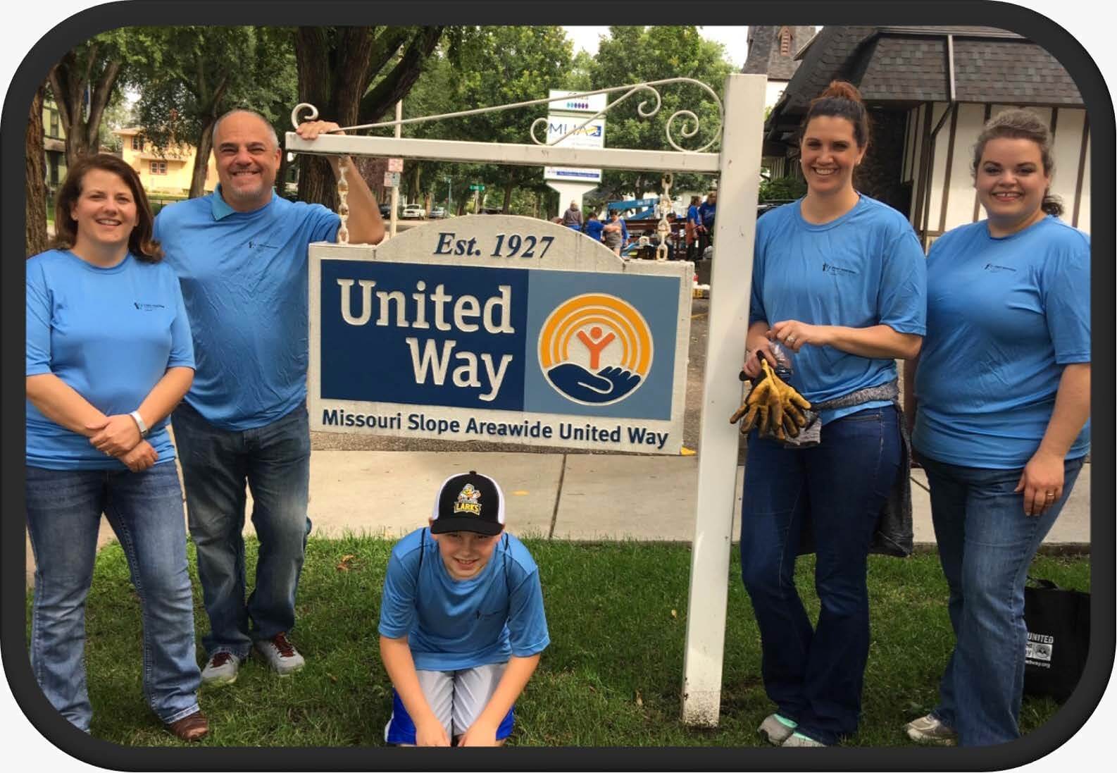 Employees standing by a United Way sign